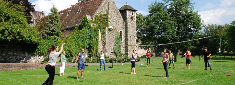 students playing volleyball by a school